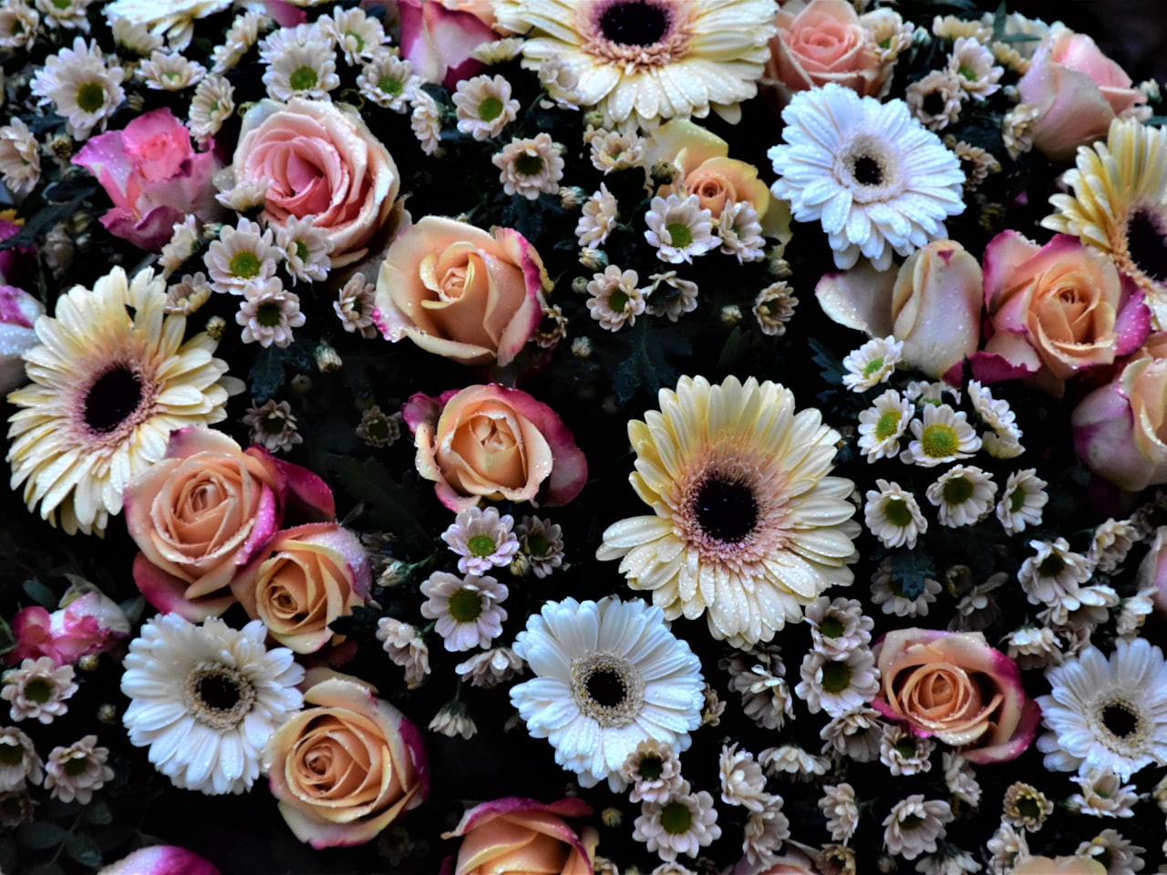 A loose, romantic hand-tied bouquet of seasonal British flowers in soft pink and sage tones