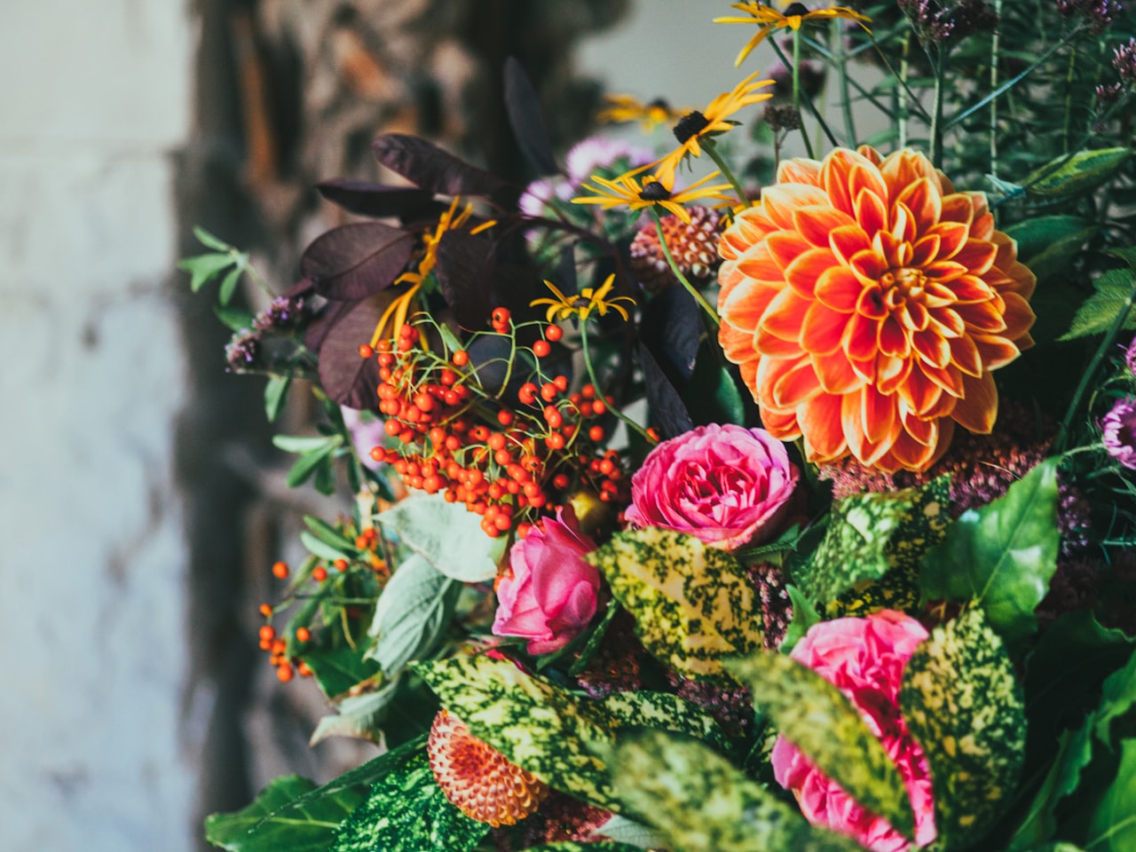 Lottie, founder of Wildflower and Fern, arranging flowers at her studio bench in Bath